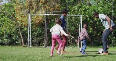 Mutlu Afro-Amerikan ailesi parkta futbol oynuyor. Aileyle açık hava konsepti ile kaliteli zaman geçirmek.