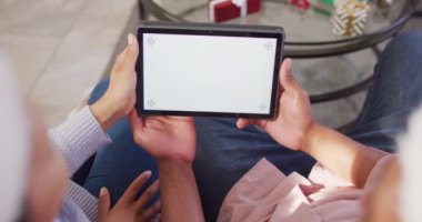 Noel Baba şapkalı mutlu Afro-Amerikan çift fotokopi odasıyla tablet görüntülü görüşme yapıyorlar. Noel 'de birlikte güzel vakit geçirmek..