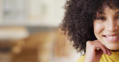 Oturma odasında gülümseyen Afrikalı Amerikalı kadın portresi. Evde yalnız zaman geçirmek..