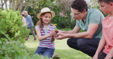 Güneşli bir günde bahçede çalışan mutlu bir beyaz aile. Ev kavramında aileyle kaliteli zaman geçirmek.