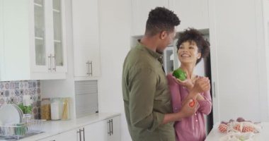 Mutfakta sebzeleri olan mutlu Afro-Amerikan çift. Evde birlikte vakit geçirmek kavramı..