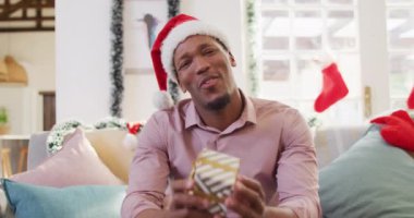 Noel Baba şapkalı mutlu Afro-Amerikalı bir adamın portresi. Noel 'de yalnız zaman geçirmek..