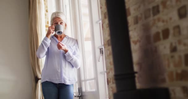 Mulher Caucasiana Sênior Feliz Quarto Olhando Pela Janela Bebendo Café — Vídeo de Stock