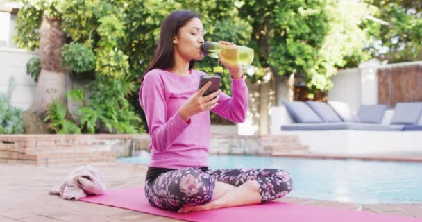 Biracial Kvinna Praktiserar Yoga Och Dricksvatten Trädgården — Stockvideo