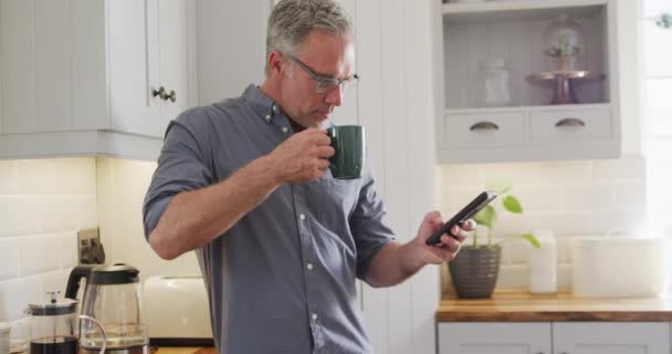 Hombre Caucásico Feliz Usando Teléfono Inteligente Beber Café Cocina Pasar — Vídeo de stock