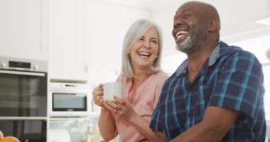 Mutlu kıdemli çift yemek pişiriyor ve bahçede çalışıyor. Evde ve emeklilik konseptinde kaliteli zaman geçirmek.