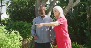 Bahçede yürüyen mutlu kıdemli çift. Evde ve emeklilik konseptinde kaliteli zaman geçirmek.