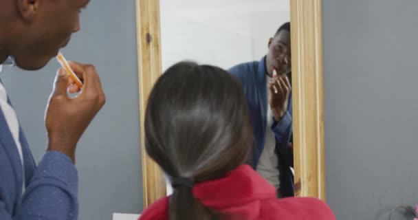 Видео Счастливой Разнообразной Пары Чистящей Зубы Смотрящей Зеркало Смеющейся Ванной — стоковое видео