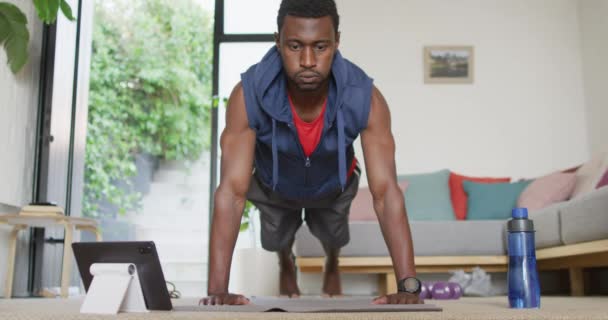 幸せなアフリカ系アメリカ人男性のリビングルームで タブレットを使用して運動 自宅だけで質の高い時間を過ごす — ストック動画