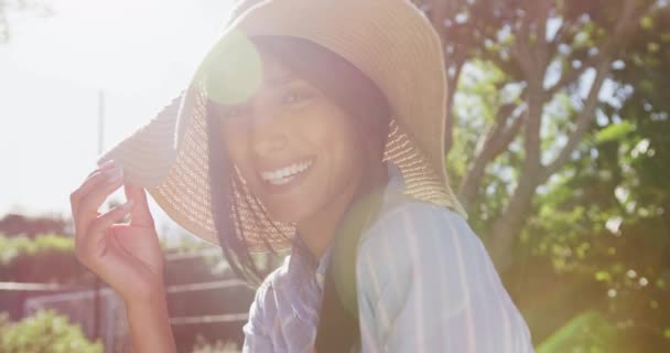 Videoportræt Glad Racistisk Kvinde Iført Solhat Solrig Have Smilende Til – Stock-video