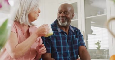 Oturma odasında oturup kahve içen mutlu kıdemli çift. Evde ve emeklilik konseptinde kaliteli zaman geçirmek.