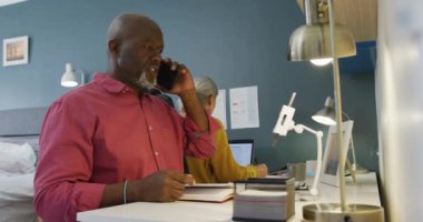 Mutlu kıdemli çift masada oturuyor ve çalışıyor. Evde ve emeklilik konseptinde kaliteli zaman geçirmek.