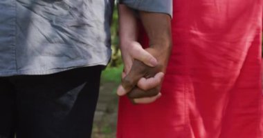 Bahçede yürüyen yaşlı ve çeşitli çiftlerin yakın çekimleri. Evde ve emeklilik konseptinde kaliteli zaman geçirmek.