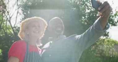 Mutlu kıdemli çift bahçede selfie çekiyor. Evde ve emeklilik konseptinde kaliteli zaman geçirmek.