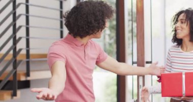 Melez adam, çeşitli bayan arkadaşlarını çiçeklerle ve Noel hediyeleriyle karşılıyor. Noel, kutlama, gelenek, arkadaşlık, kapsayıcılık ve yaşam tarzı konsepti.