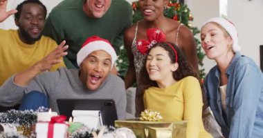 Mutlu arkadaş grubu Noel partisinde video araması için tablet kullanıyor. Noel 'de evde birlikte vakit geçirmek..