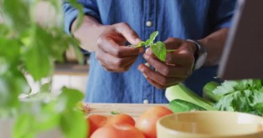 Afro-Amerikan bir adamın orta kesiminde mutfakta yemek pişirmesi. Evde yalnız zaman geçirmek..
