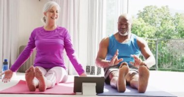 Yoga ve esneme pratiği yapan mutlu kıdemli çift. Evde ve emeklilik konseptinde kaliteli zaman geçirmek.
