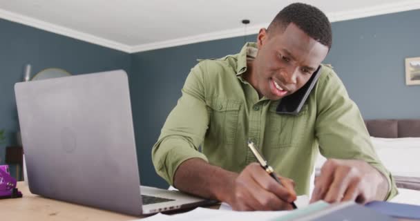 Vídeo Homem Afro Americano Usando Laptop Falando Smartphone Escrevendo Notas — Vídeo de Stock