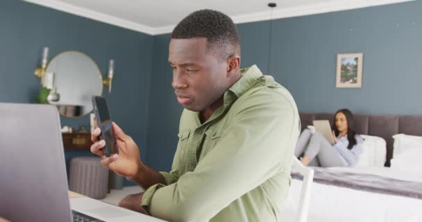 Video Una Pareja Diversa Dormitorio Hombre Sentado Usando Teléfono Inteligente — Vídeos de Stock