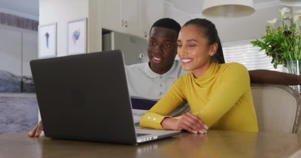 Видео Счастливой Разнообразной Пары Смотреть Ноутбук Вместе Улыбаясь Сидя Кухне — стоковое видео