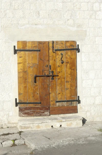 Kőburkolatú homlokzat, a régi, fából készült ajtók — Stock Fotó