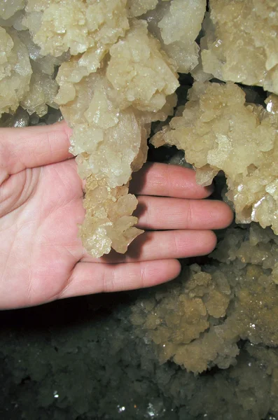 Druze gypsum crystals in the cave and the hand — Zdjęcie stockowe