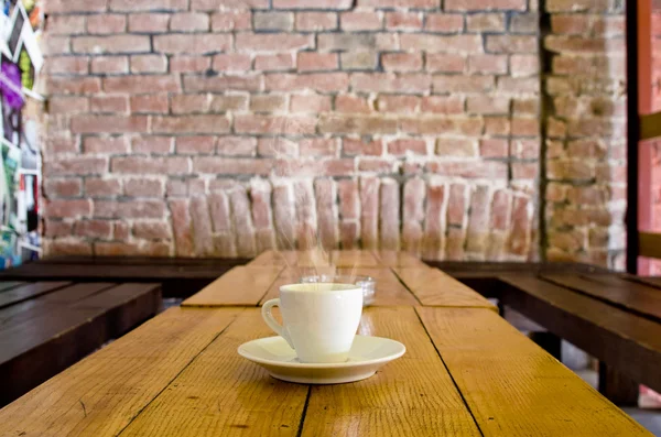 bir barda ahşap bir masa üzerinde kahve kupa