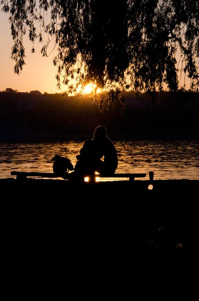 夕日と湖のそばのベンチに愛好家 — ストック写真