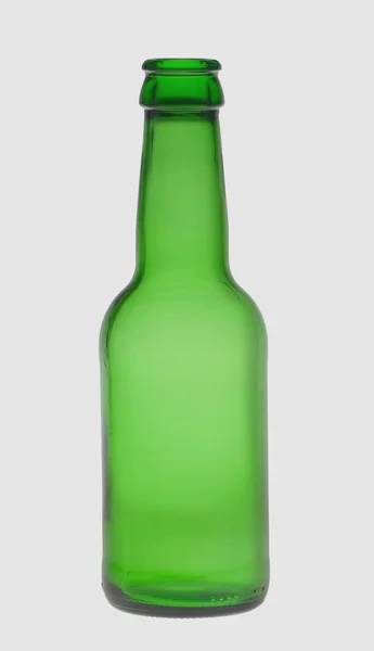Зеленая бутылка пива, на сером фоне, на сером фоне — стоковое фото