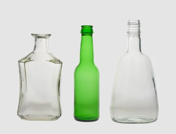 Diferentes botellas vacías, sobre un fondo gris —  Fotos de Stock
