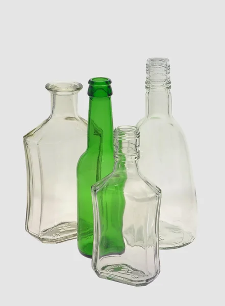 4 botellas vacías diferentes, sobre un fondo gris —  Fotos de Stock
