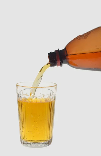Derramando cerveja em um copo, em um fundo cinza — Fotografia de Stock