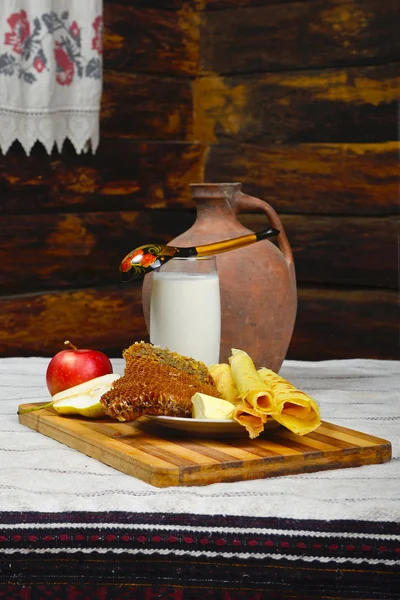 Méz a fésű, a tej és a palacsinta az asztalon — Stock Fotó