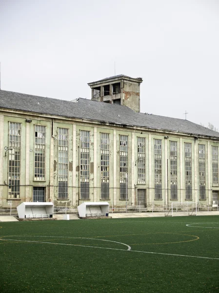 Edifício abandonado com campo de futebol — Fotografia de Stock