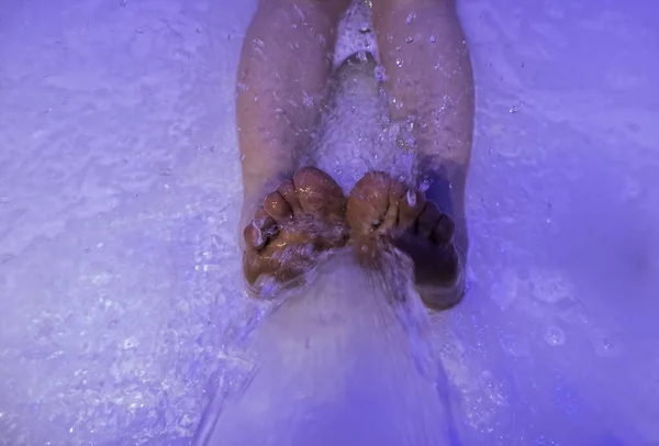 Feet in jacuzzi getting wet with jets, treatment and relaxation