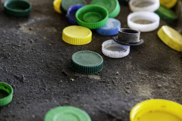 Dirty plastic caps in barrel, recycling and environment