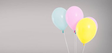 colored helium balloons isolated on grey background, birthday concept