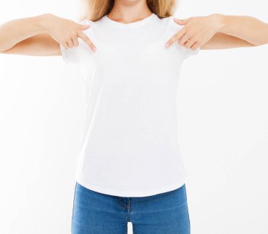 Beyaz arka planda izole edilmiş beyaz tişörtünü parmaklarıyla gösteren çekici beyaz kadın.