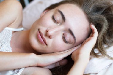 Uyuyan kadın yakın çekim, uyuyan kız, yatakta yatan kadın, iyi uyku, uykusuzluk, sağlık hizmeti. Seçici odak