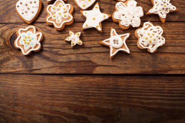 Koyu kahverengi ahşap arka planda Noel kurabiyeleri çerçevesi. Üst görünüm ve boşluk kopyala. Model yap. Mutlu yıllar konsepti