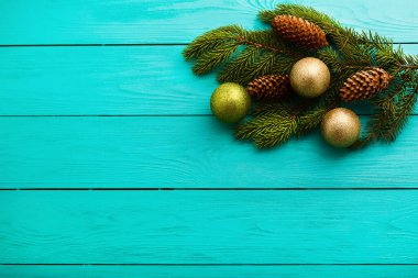 Mavi ahşap arka planda bir Noel ağacının üzerindeki çam kozalakları. Üst görünüm ve kopyalama alanı