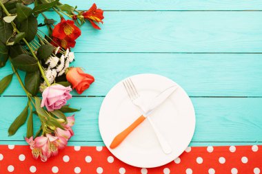 Kutlama yemeği ve mavi ahşap arka planda güller. Üst Manzara. Model yap. Çiçekler.