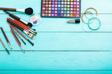 Mavi ahşap arka planda kozmetik ve aksesuarlar. Üst görünüm