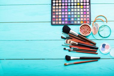 Mavi ahşap arka planda kozmetik ve aksesuarlar. Üst görünüm