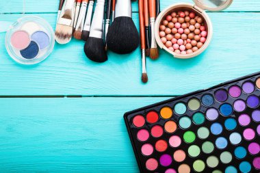 Mavi arkaplanda fotokopi alanı olan kozmetik aksesuarlar çerçevesi. Üst görünüm