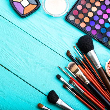 Mavi ahşap arka planda makyaj malzemeleri. Üst görünüm