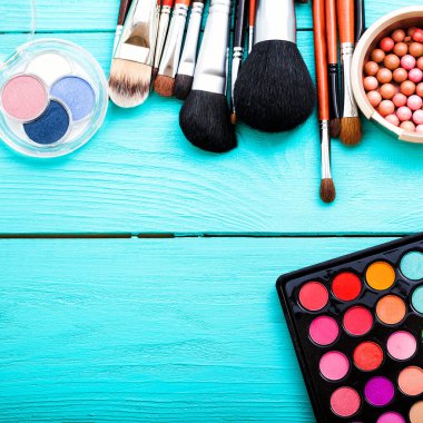 Mavi arkaplanda fotokopi alanı olan kozmetik aksesuarlar çerçevesi. Üst görünüm