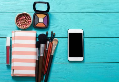 Aksesuarları uydur. Üst Manzara. Mavi ahşap arka plan. Boş ekranlı cep telefonu.