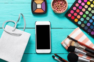 Aksesuarları uydur. Üst Manzara. Mavi ahşap arka plan. Boş ekranlı cep telefonu.